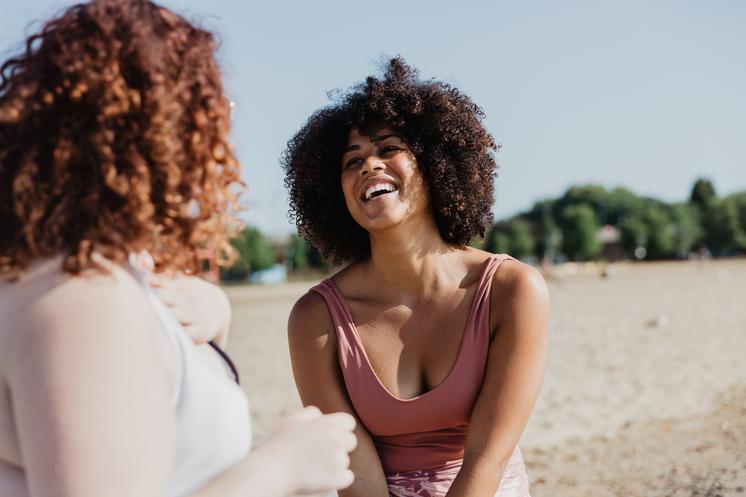 Two women laughing in a park.